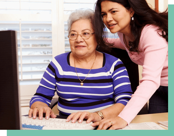 A woman and an older person using a computer.